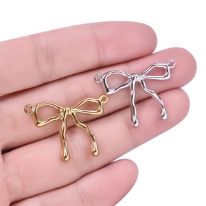 Detail of 304 stainless steel bow pendants in gold and silver for DIY jewelry
