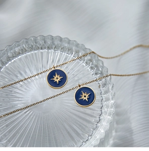 Macro detail of blue enamel compass pendant with gold star on ribbed glass