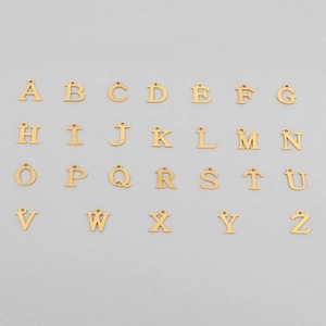 Close-up of 26 gold stainless steel alphabet pendants from A to Z for DIY necklaces