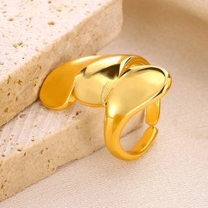 Macro shot of gold abstract fluid sculpture ring on natural stone showing mirror finish
