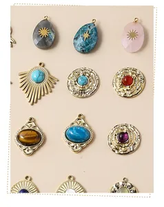 Detailed close-up of mixed geometric brass charms with inlaid natural gemstones and sun motifs