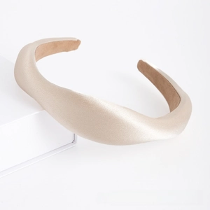 Detail of a padded champagne satin headband with non-slip brown velvet inner lining
