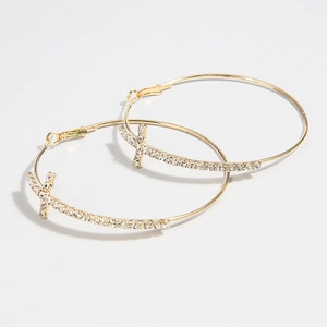 Detailed view of golden hoop earrings featuring diamond-encrusted cross pendants