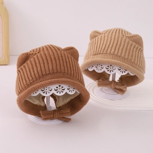 Dettaglio di cappelli per neonati in maglia con orecchie e fiocco regolabile