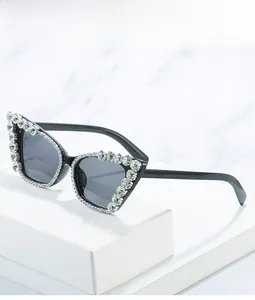 Detailed view of black cat eye sunglasses featuring crystal rhinestones on marble surface