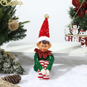 Detailed view of seated Christmas elf doll with red sequins and festive holiday props