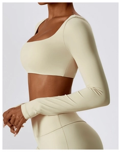 Détail de l'ensemble de yoga crème avec haut court à manches longues et legging taille haute