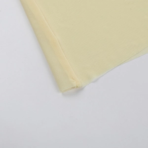 Detailed view of light yellow mesh fabric with translucent grid structure and fine seams