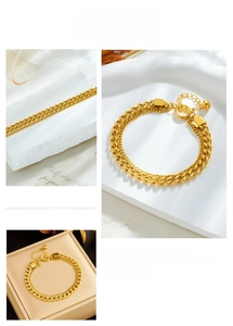 Detail of gold double-layered chunky chain bracelet with heart charm and spring clasp