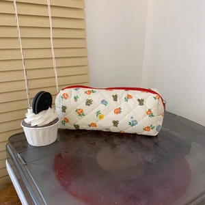 Macro shot of quilted cream fabric pencil case featuring floral and bear prints
