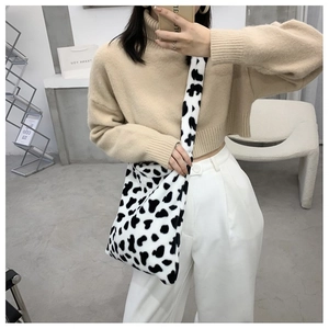 Mirror selfie showing the fluffy cow print plush crossbody bag on a model shoulder