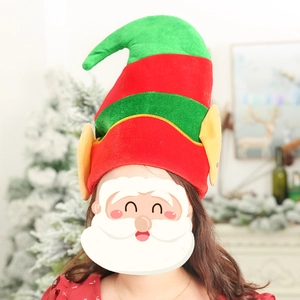 Festive red and green striped Christmas elf hat with yellow ears on holiday background