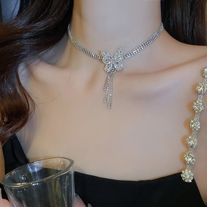 Détail du collier ras du cou en strass argenté avec pendentif papillon et glands pendants