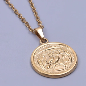 Detail macro view of 18k gold bird owl pendant with AΘE engraving on stainless steel chain