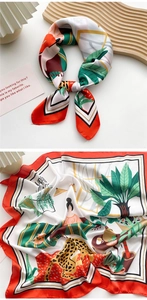 Detailed macro view of an artistic silk scarf with leopard print and tropical botanical motifs