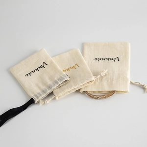 Detailed texture of cotton linen drawstring jewelry pouches with gold bracelet