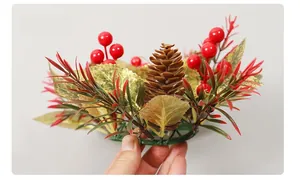 Vue latérale d'une couronne de Noël avec pommes de pin, baies rouges et feuilles dorées