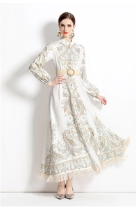 Détail d'une robe longue blanche imprimée avec glands et ceinture assortie