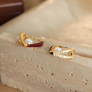 Vintage French heart enamel earrings with white pearls and red glaze on a stone platform