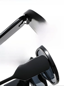Detail shot of sturdy metal hinges and glossy black oversized frame on fashion sunglasses