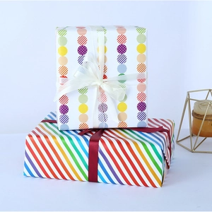 Colorful dot and rainbow stripe gift wrapping paper with decorative ribbon bows