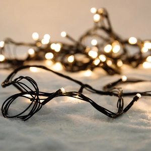 Warm white LED Christmas string lights on green wire with bokeh background effect