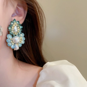 Macro view of vintage floral earrings with layered green petals and pearls