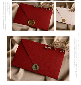 Detail of vintage linen envelopes in red and beige with gold wax seals on silk fabric