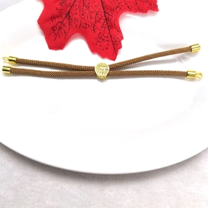 Close-up of brown Milanese cord bracelet with 18k gold plated bead and adjustable clasp