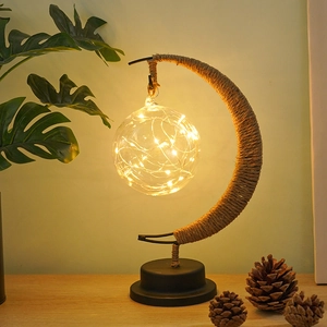 Macro shot of warm LED crescent moon lamp with twine wrapping and clear bulb detail