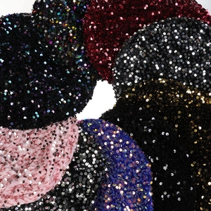 Close-up of sparkling sequin hair scrunchie texture in various colors on white background