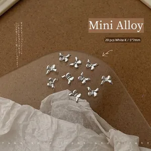 Detailed view of 20pcs silver bow-shaped nail art alloy charms sized 5x7mm each