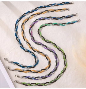 Close-up of multi-layer snake chain necklaces in four mixed-color woven steel designs