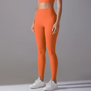 Detailed close-up of high-waisted seamless orange yoga pants with moisture-wicking fabric