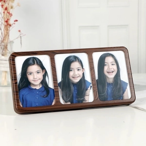 Three-panel walnut wood photo frame with rounded corners on a minimalist white desk