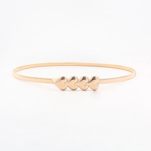 Close-up of golden elastic metal spring belt featuring four interlocking heart buckles