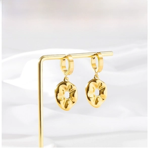 Detailed view of gold plated earrings featuring irregular textured round charms