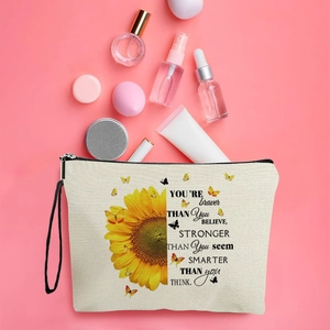 Sunflower makeup bag with butterfly print and hand strap on pink background