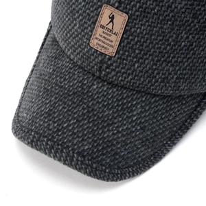 Detail of dark grey knit baseball cap featuring premium wool texture and leather patch