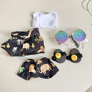 Flat lay of doll clothing set including white top, black animal print outfit, and sunglasses