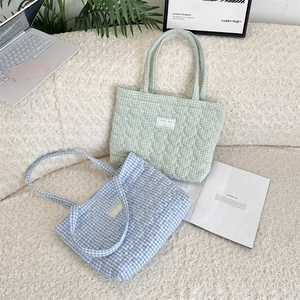 Détail du matelassage en forme de cœur et de l'étiquette sur les sacs à carreaux