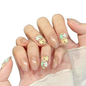Handmade almond blossom press-on nails with floral patterns on shimmering nude base