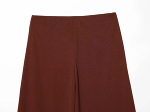 Detailed macro view of dark brown wide-leg trousers showing waistband and fabric texture