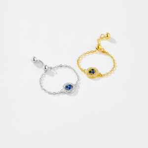 Detail view of adjustable chain rings in gold and silver with blue clover zircon inlay