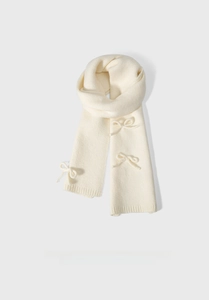 Detail shot of a cream-white knitted scarf featuring three decorative elegant bows