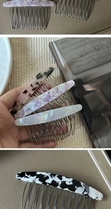 Detail of acetate hair side combs with metal teeth in pink leopard and marble patterns