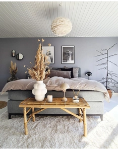 Detail of white bubble ceramic vase on a bamboo bench in a Nordic style bedroom