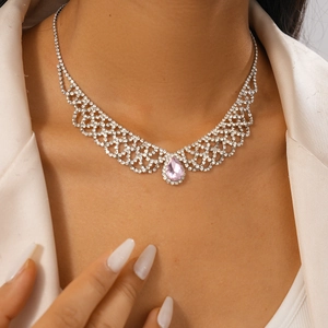 Close-up of a silver grid pendant necklace with pink teardrop gem and sparkling diamonds