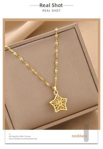 Detail of gold moon and star hollow pendant necklace with woven texture and leaf chain