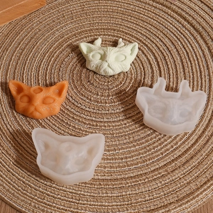 DIY devil cat resin molds and finished silicone cat charms on a woven mat background